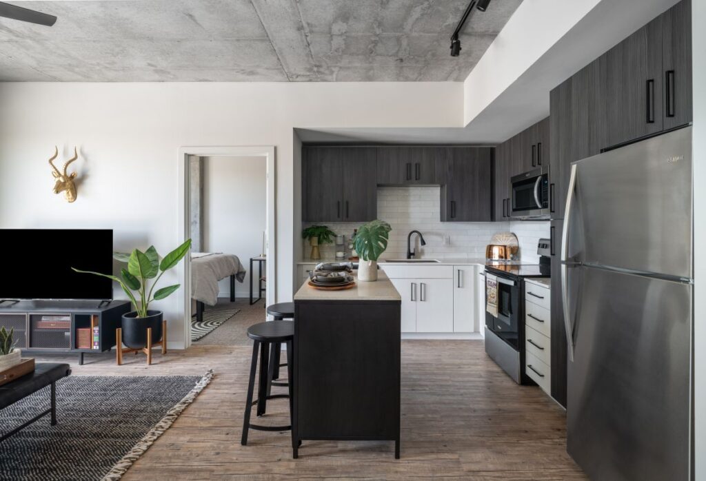 Rev Student Living Common Room with Seating Area and Chef's Kitchen With Luxury Gray Cabinets and Appliances